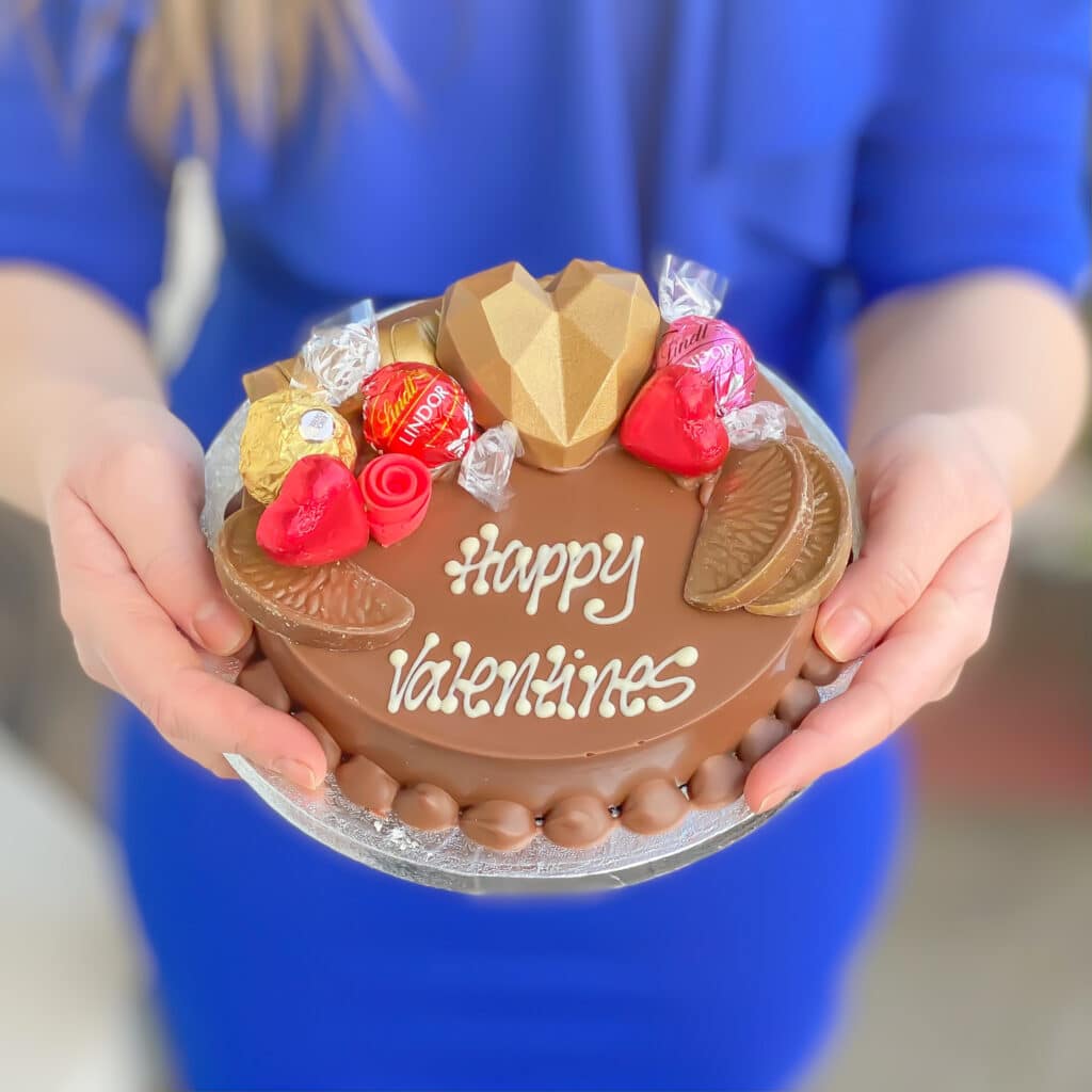 Woman holding a Valentines Day smash cake